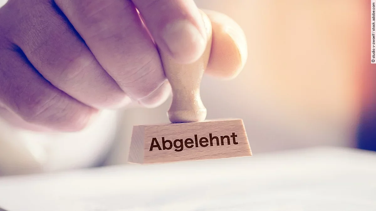 Eine Hand hält einen Stempel mit dem Aufdruck Abgelehnt