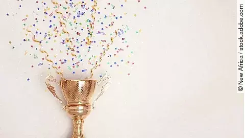 Eine Trophähe aus Gold, aus der Konfetti kommt.