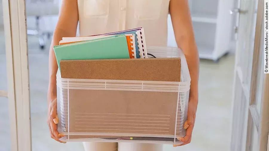 Kündigung Der Torso einer Frau: Sie hält einen Pappkarton mit einigen Dokumenten darin.