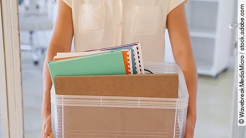 Kündigung Der Torso einer Frau: Sie hält einen Pappkarton mit einigen Dokumenten darin.