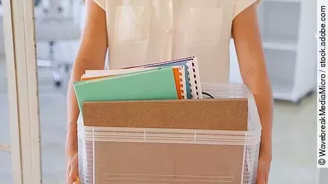 Kündigung Der Torso einer Frau: Sie hält einen Pappkarton mit einigen Dokumenten darin.