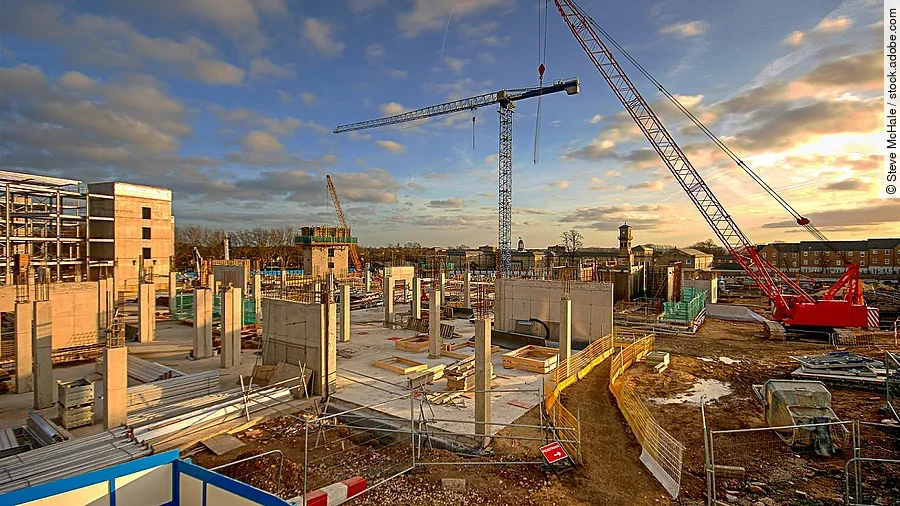 Baustelle mit Bodenplatte und Kran.