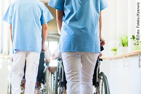 Krankenpfleger mit Patient im Rollstuhl