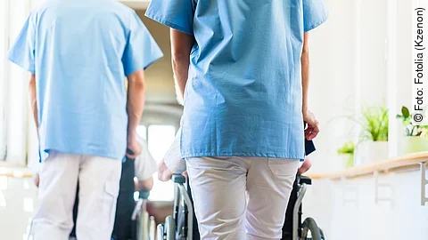 Krankenpfleger Krankenpfleger mit Patient im Rollstuhl