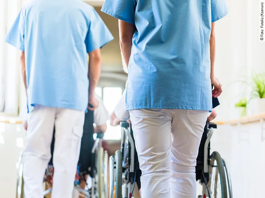 Krankenpfleger mit Patient im Rollstuhl