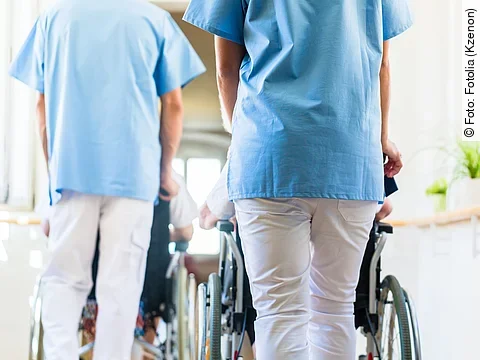 Krankenpfleger mit Patient im Rollstuhl