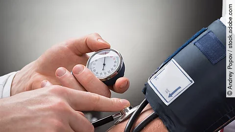 Blutdruck Eine Person misst den Blutdruck einer anderen Person mittels Oberarm-Blutdruckmessgerät.