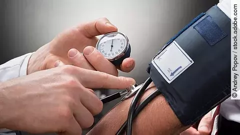 Eine Person misst den Blutdruck einer anderen Person mittels Oberarm-Blutdruckmessgerät.