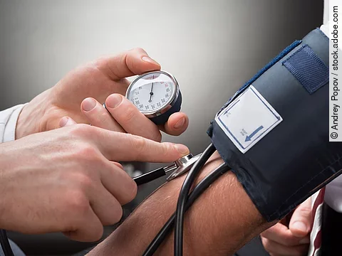 Eine Person misst den Blutdruck einer anderen Person mittels Oberarm-Blutdruckmessgerät.