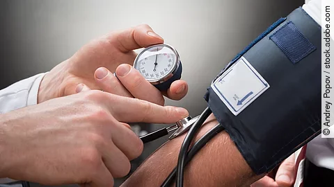 Eine Person misst den Blutdruck einer anderen Person mittels Oberarm-Blutdruckmessgerät.