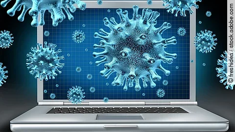 Ein aufgeklappter Laptop umgeben von schwebenden Viren (kugelförmige Objekte mit Noppen).