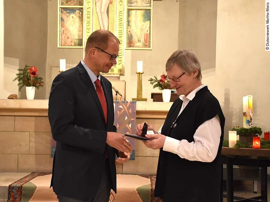 Oberkirchenrat Stolte überreicht Barbara Ide das goldene Kronenkreuz
