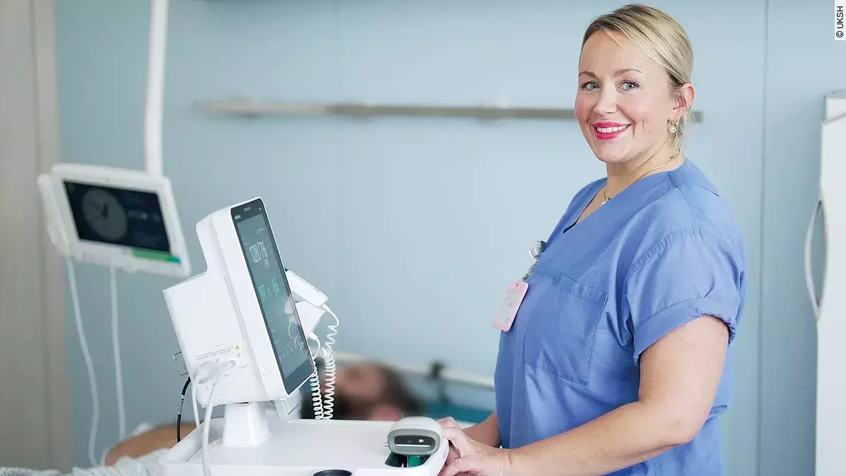 Pflegefachkraft steht am Monitor