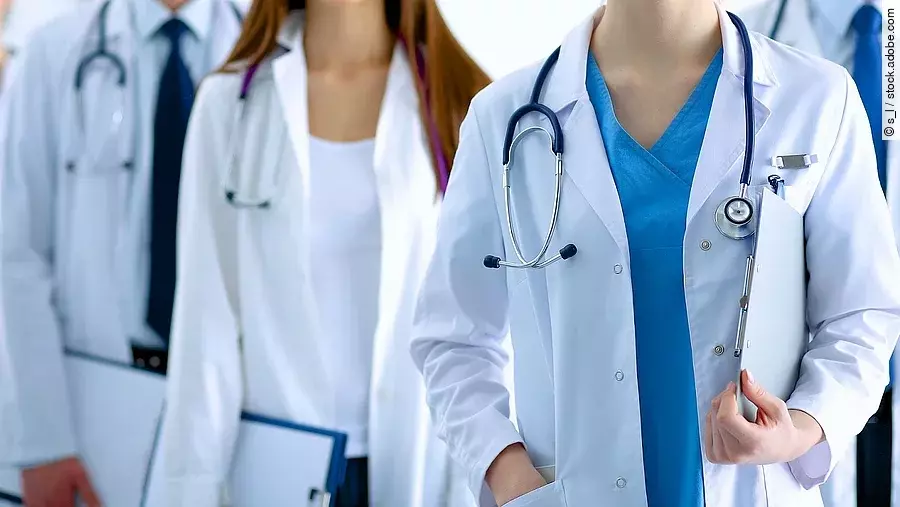 Ärzteteam in Arbeitskleidung steht nebeneinander.