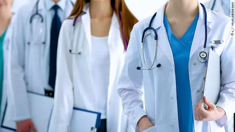 Ärzteteam in Arbeitskleidung steht nebeneinander.