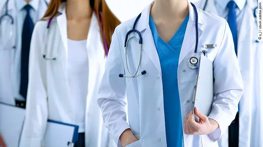 Ärzteteam in Arbeitskleidung steht nebeneinander.