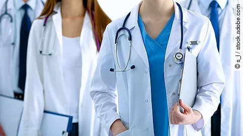 Ärzteteam in Arbeitskleidung steht nebeneinander.