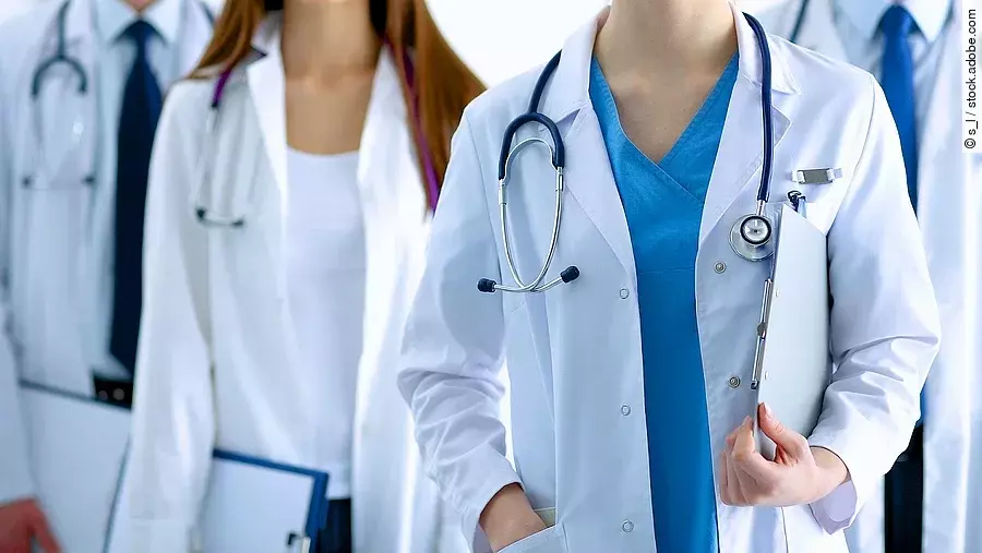 Ärzteteam in Arbeitskleidung steht nebeneinander.