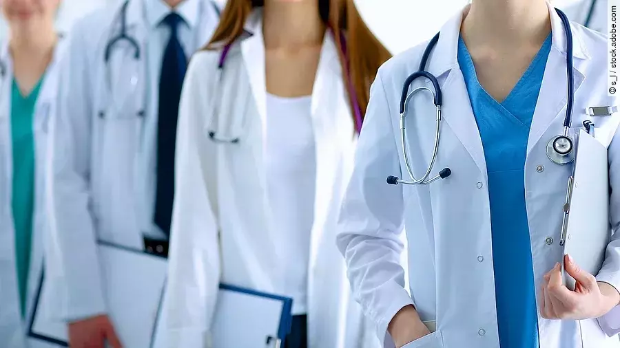 Ärzteteam in Arbeitskleidung steht nebeneinander.