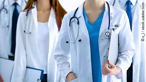 Ärzteteam in Arbeitskleidung steht nebeneinander.