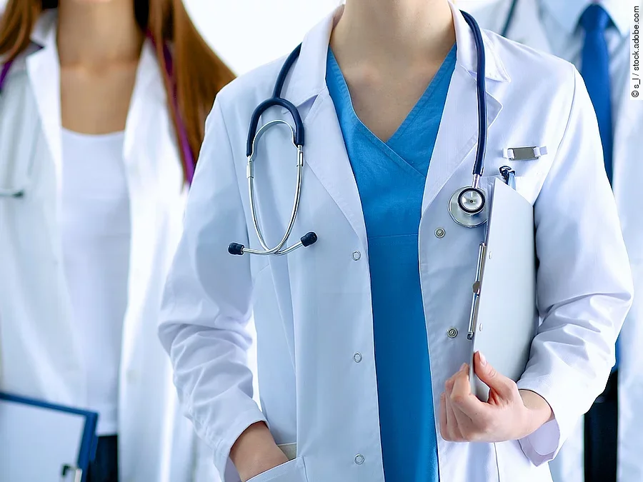 Ärzteteam in Arbeitskleidung steht nebeneinander.