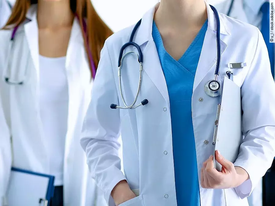 Ärzteteam in Arbeitskleidung steht nebeneinander.