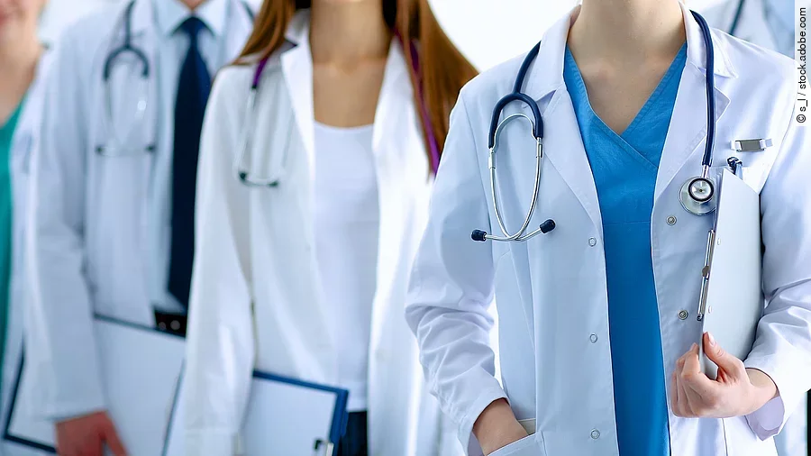 Ärzteteam in Arbeitskleidung steht nebeneinander.