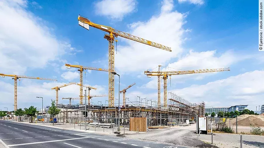 Großbaustelle an einer Straße mit mehreren Kränen.