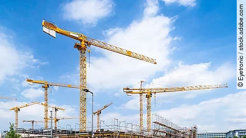 Großbaustelle an einer Straße mit mehreren Kränen.