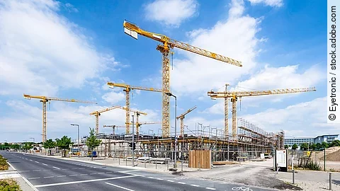 Großbaustelle an einer Straße mit mehreren Kränen.