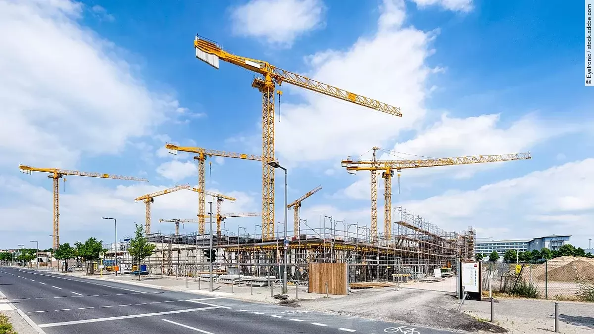 Großbaustelle an einer Straße mit mehreren Kränen.