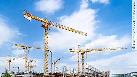 Großbaustelle an einer Straße mit mehreren Kränen.