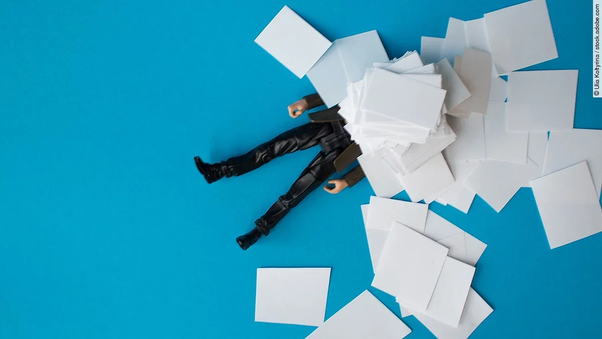 Bürokratie Eine Person liegt vergraben unter einem Papierstapel