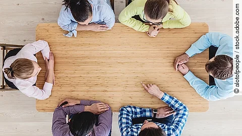 Gesprächsrunde mit sechs Personen an einem hölzernen Tisch