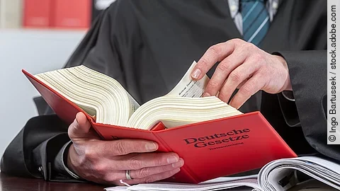 Gericht Ein Anwalt blättert in einem deutschen Gesetzbuch.