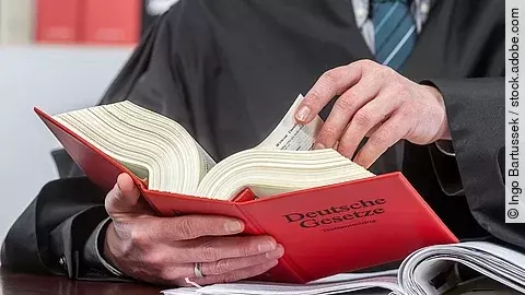 Ein Anwalt blättert in einem deutschen Gesetzbuch.