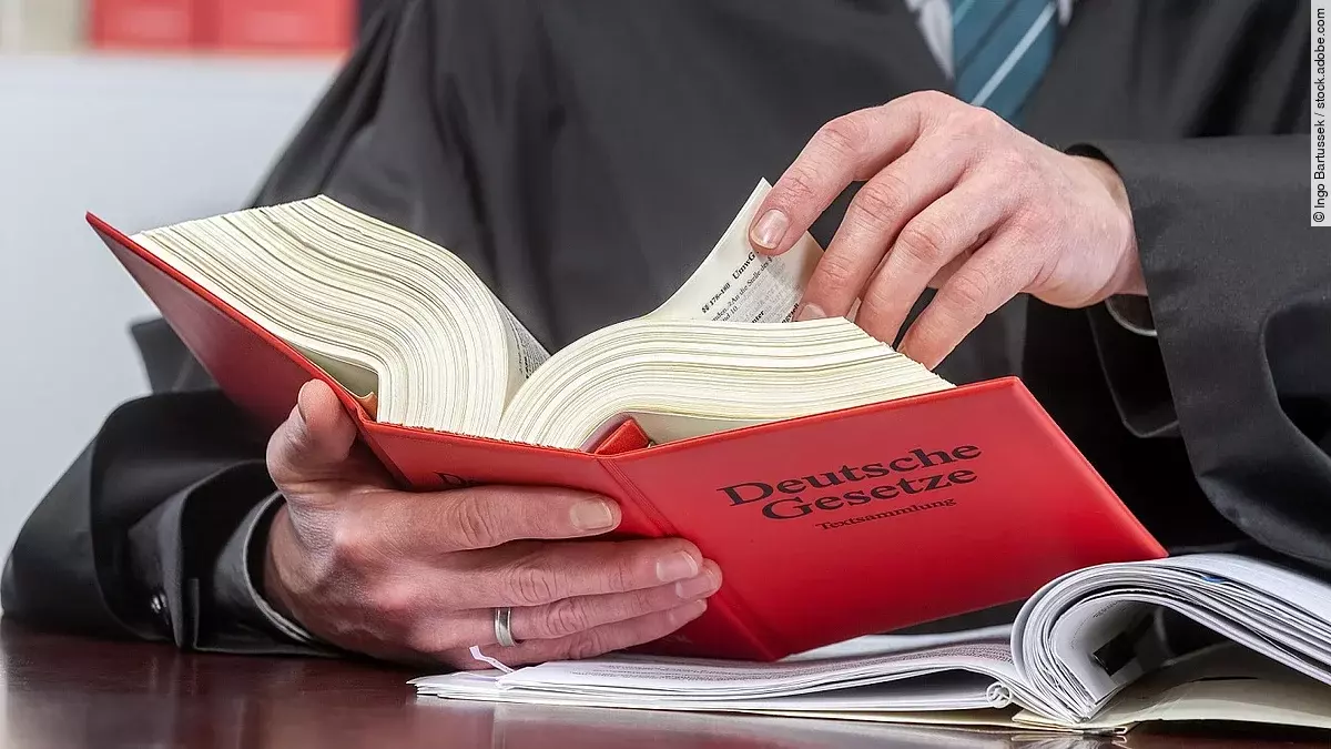 Ein Anwalt blättert in einem deutschen Gesetzbuch.