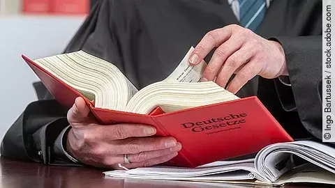 Ein Anwalt blättert in einem deutschen Gesetzbuch.