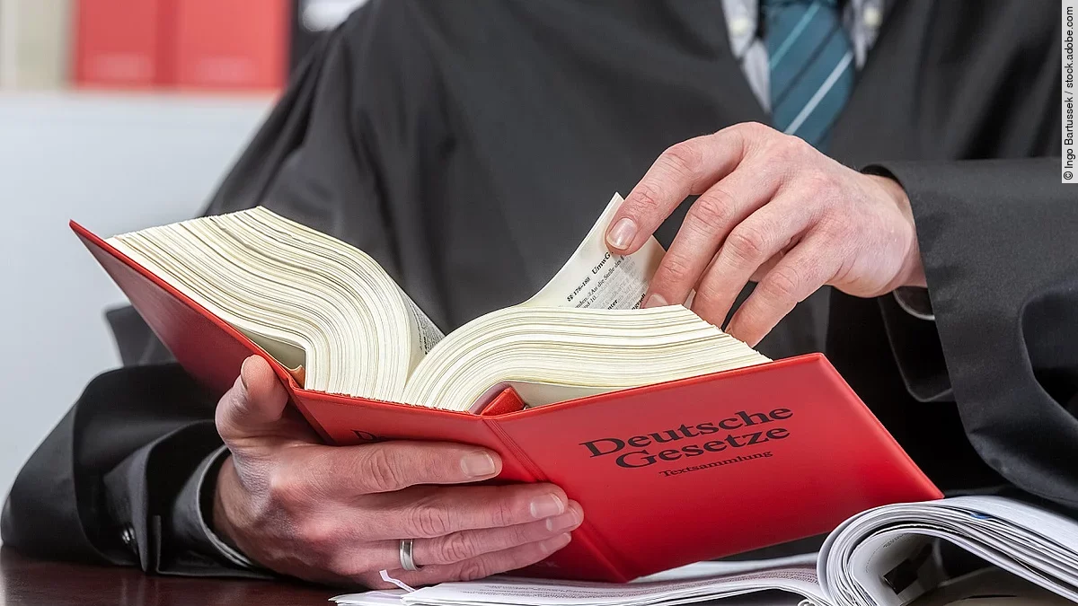 Gericht Ein Anwalt blättert in einem deutschen Gesetzbuch.