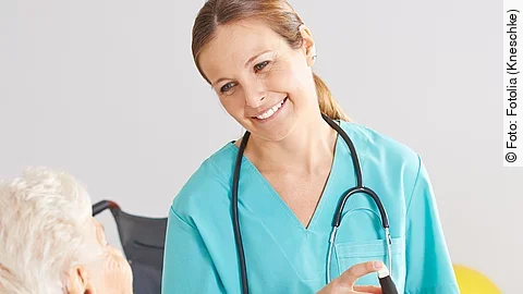 Patientin im Rollstuhl mit Krankenpflegerin