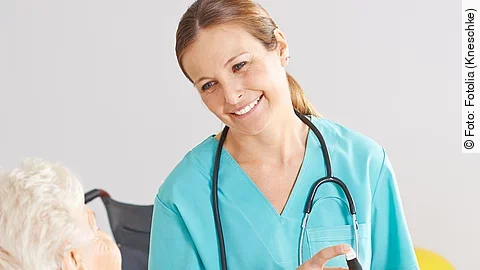 Krankenpflegerin Patientin im Rollstuhl mit Krankenpflegerin