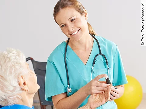 Patientin im Rollstuhl mit Krankenpflegerin