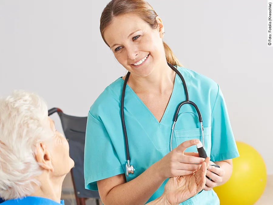 Patientin im Rollstuhl mit Krankenpflegerin