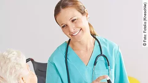 Patientin im Rollstuhl mit Krankenpflegerin