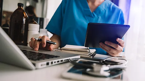 Arzt mit Smartphone und Tablet