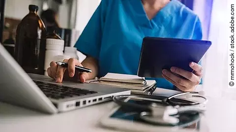 Arzt mit Smartphone und Tablet