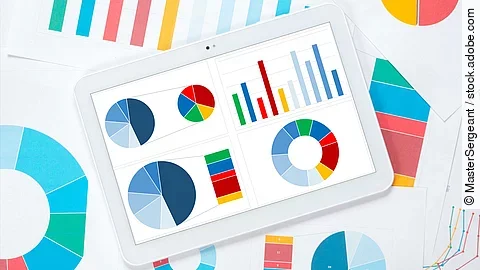 Mehrere Dokumente mit bunten Diagrammen liegen übereinander. 
