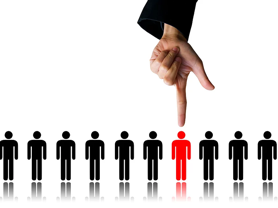 Zehn Menschen (Piktogramme) stehen nebeneinander. Eine Hand zeigt auf eine rote Figur.