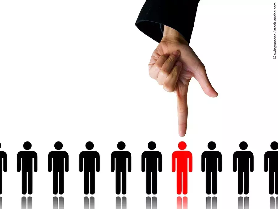 Zehn Menschen (Piktogramme) stehen nebeneinander. Eine Hand zeigt auf eine rote Figur.