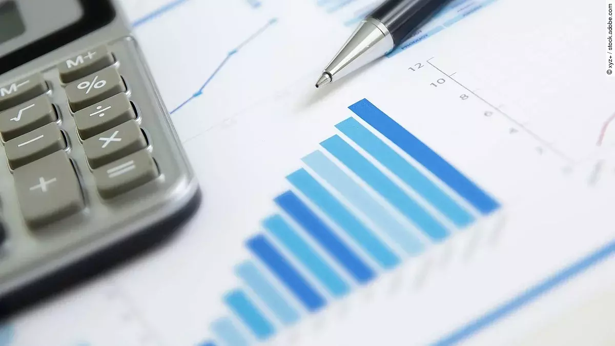 Ein Blatt Papier worauf ein Balkendiagramm abgebildet ist. Daneben liegt ein Tasschenrechner.